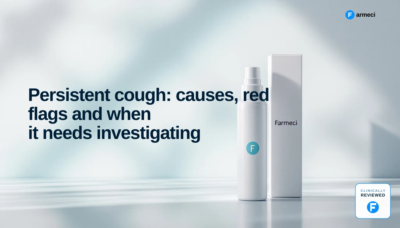 Woman sitting on a sofa at home holding a mug and pressing a tissue to her mouth mid-cough
